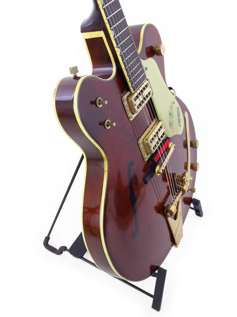 A vintage 1967 Gretsch 6122 Chet Atkins guitar displayed on a stand, highlighting its beautiful wooden body.