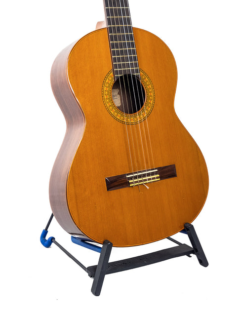 A vintage 1987 K Yairi YC90 Concert Classical Guitar resting on a stand with a plain white backdrop.