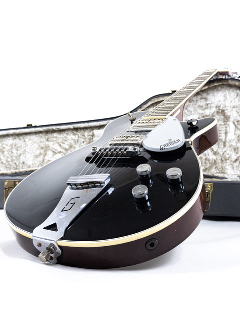 A vintage 1989 black Gretsch Duo Jet 6128 guitar in its case, displayed on a stark white background.