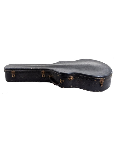 A vintage black guitar case, the Gibson L 7 Special from the 1940s, resting on a bright white surface.