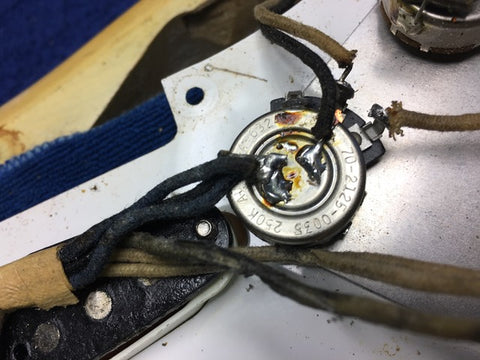 A vintage blond Fender Stratocaster from 1959, displaying a broken wire and a classic maple neck.