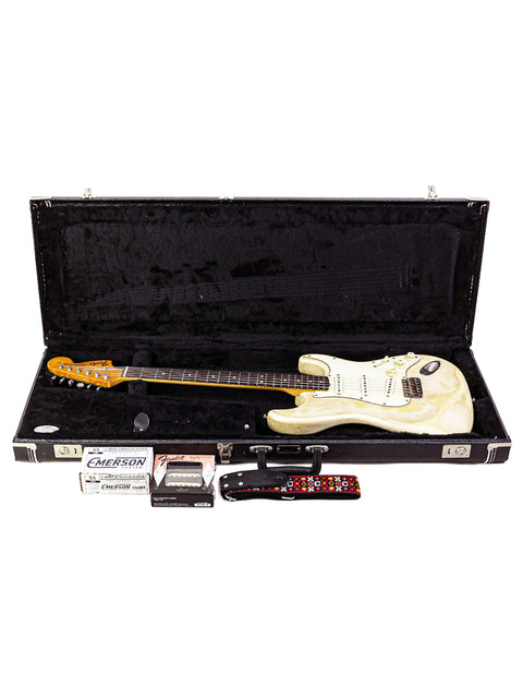 A white 1968 Fender Stratocaster guitar in a protective case, featuring a guitar pick for added charm.