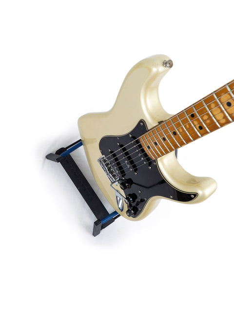 A white Fender 25th Anniversary Stratocaster electric guitar featuring a sleek black pick guard.