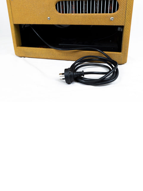 A yellow Fender Blues Junior III amplifier from 2012, with a cord plugged in, ready for music performance.