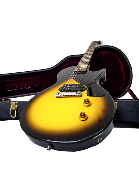 A yellow electric guitar securely placed in a case, representing the Gibson Custom Shop '57 Les Paul Junior Reissue VOS, USA 2007.