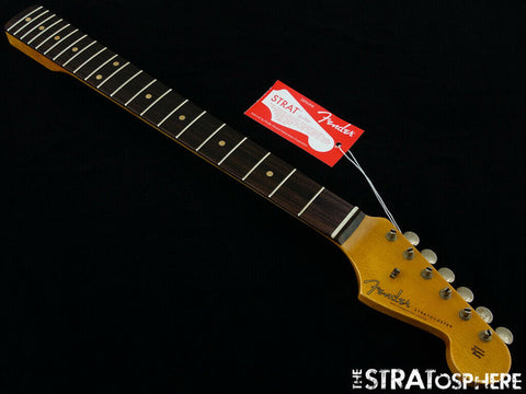 An Olympic White Fender guitar labeled with a tag, representing a '60s Strat Partscaster with Custom Shop components from 2020.