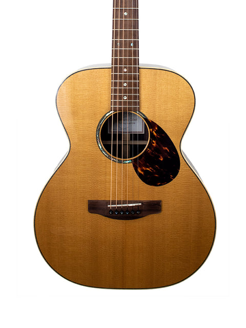 An acoustic guitar, Gerard Gilet 000 14 Fret, displayed against a clean white background, showcasing its elegant design.