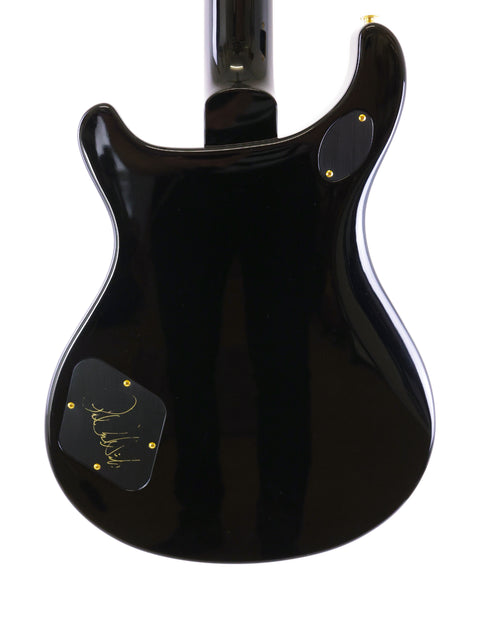 Black PRS McCarty 594 guitar, USA-made in 2016, adorned with a gold sticker on the back for a touch of flair.