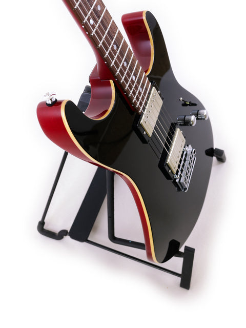 Black Suhr Pete Thorn Signature electric guitar on a stand, showcasing its sleek design and craftsmanship from USA 2021.