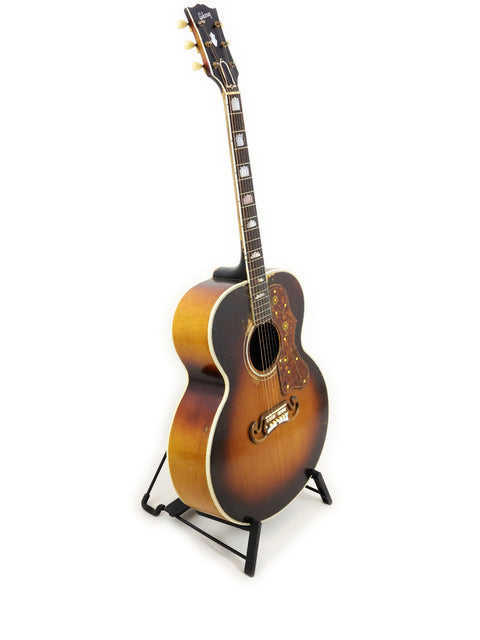 Classic 1954 Vintage Gibson J-200 guitar resting on a stand with a bright white background.