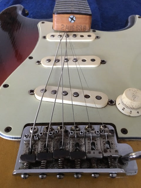 Close-up image of a 1964 Fiesta Red Fender L Series Stratocaster guitar, focusing on its pickup.