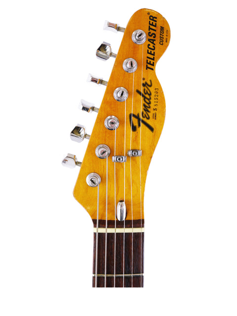 Close-up image of a 1977 Fender Telecaster Custom headstock, featuring its distinctive logo and tuning pegs.
