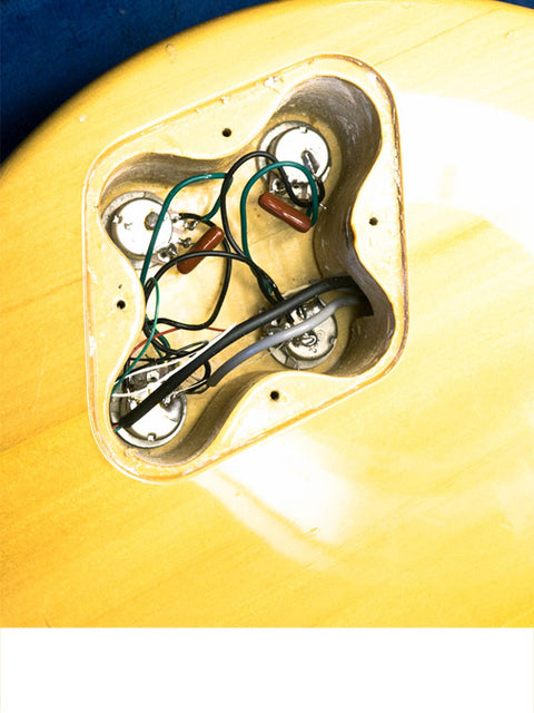 Close-up image of a Univox Gimmie U-1988 guitar, emphasizing its intricate wires and pickup, crafted in Japan, 1974-75.
