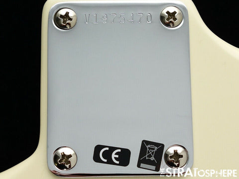 Close-up image of a guitar's back, highlighting a white pick guard on a Fender '60s Strat Partscaster in Olympic White.