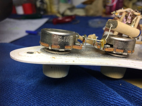 Close-up image of a vintage 1959 Fender Stratocaster, highlighting the pickup and cover on its blond maple neck.