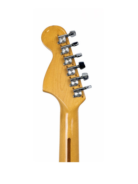 Close-up of a 1976 Fender Stratocaster guitar head, showcasing its vintage design on a white background.