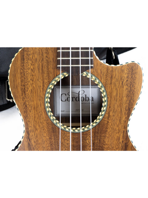 Close-up of a Cordoba guitar's soundhole and label, with strings and wood grain visible.