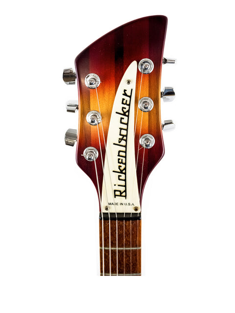 Close-up of a Fender guitar, highlighting its iconic branding alongside the Rickenbacker 330 - Fireglo from 1994.