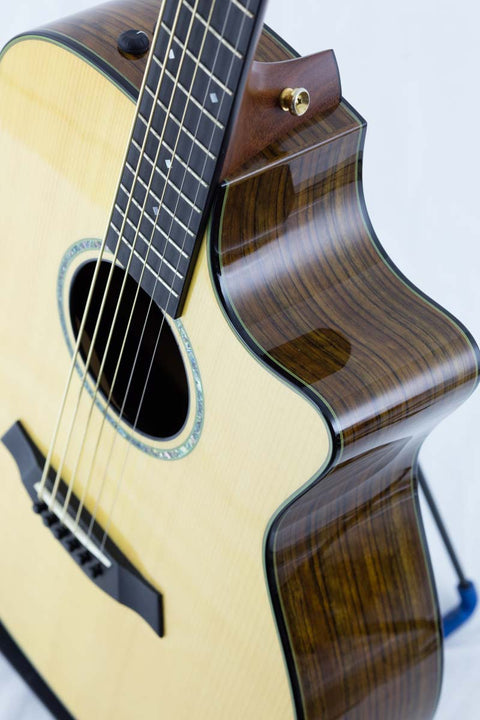 Close-up of a Taylor Custom GS Baritone 6 acoustic guitar, focusing on the beautiful wooden body and intricate details.
