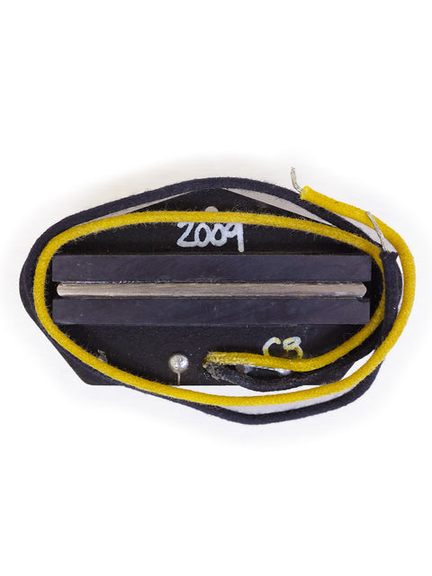 Close-up of a black and yellow guitar pick with a string, highlighting the Lollar B.S. Telecaster Bridge Pickup from 2009.