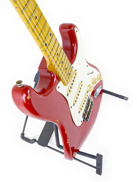 Close-up of a red Fender Custom Shop ’56 Stratocaster Relic guitar featuring a sleek black pick guard on top.