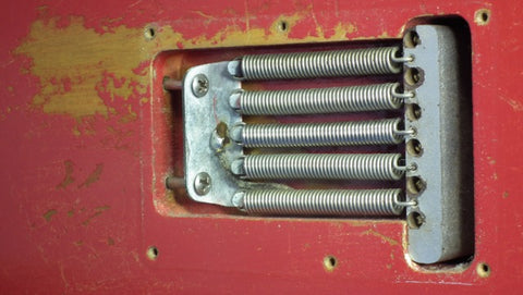 Close-up of a red door adorned with a metal latch, showcasing a blend of vintage charm and functional design.