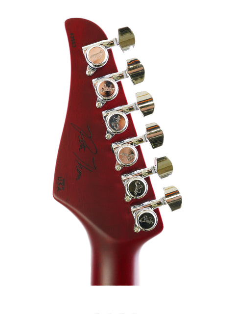 Close-up of a red headstock from a Suhr Pete Thorn Signature electric guitar, USA 2021, highlighting its unique features.