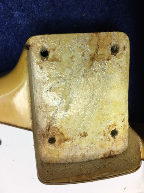 Close-up of a vintage metal plate with holes, showcasing the intricate details of a 1959 Fender Stratocaster.