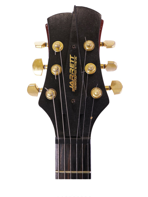 Close-up of an electric guitar headstock featuring gold hardware, labeled Jarrett Forza, Serial #00001, USA 2007.