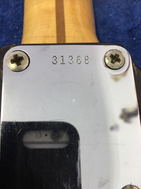 Close-up shot of the back of a 1958 Fender Stratocaster, emphasizing the rich wood texture and vintage appeal.