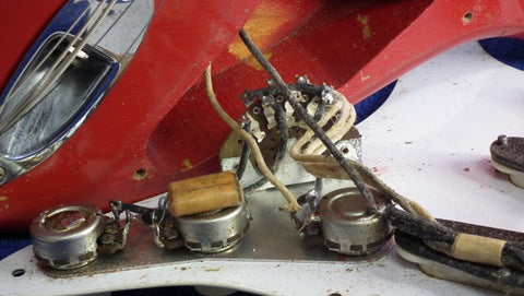 Dakota Red Vintage Fender Stratocaster from 1957, adorned with wires, exemplifying its iconic style and vintage charm.