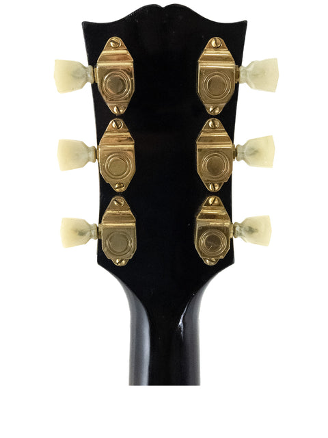 Detailed view of a 1955 Gibson L-5 CES headstock, highlighting Alnico pickups and vintage craftsmanship.