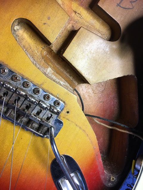 Detailed view of a 1964 Fender L Series Stratocaster in Fiesta Red, highlighting the broken neck and vintage wear.