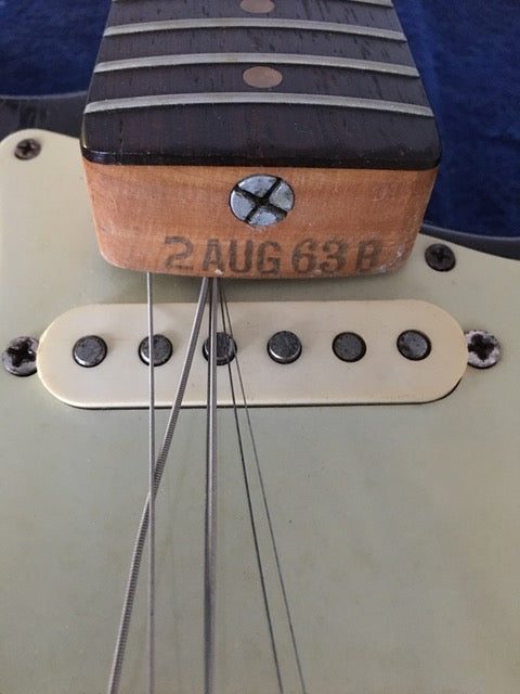 Detailed view of a 1964 Fender L Series Stratocaster in Fiesta Red, highlighting the pickup and its cover.