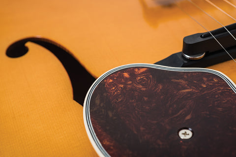 Detailed view of a 2016 Epiphone Masterbilt De Luxe F-Hole Archtop guitar showcasing its black pick guard.