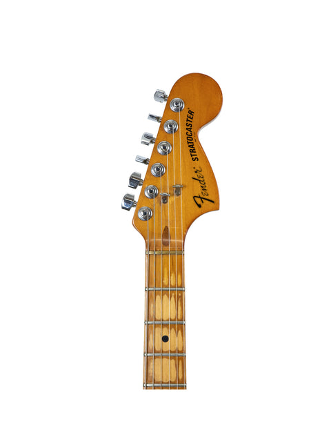 Detailed view of a Fender guitar, featuring the name prominently, representing the 1979 25th Anniversary Stratocaster.