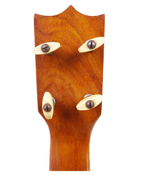 Detailed view of the headstock of a 1928 Kamaka Pineapple Style #3 ukulele, highlighting its intricate features and wood grain.
