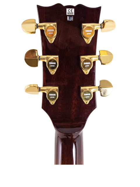 Detailed view of the headstock on a 2004 Yamaha SA 2200 Thinline guitar, showcasing its shiny gold hardware.