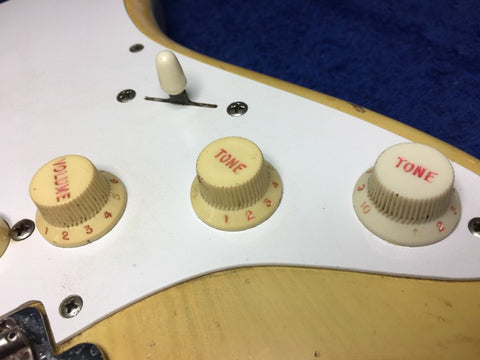 Detailed view of the knobs on a 1959 vintage Fender Stratocaster, featuring a blond body and maple neck.