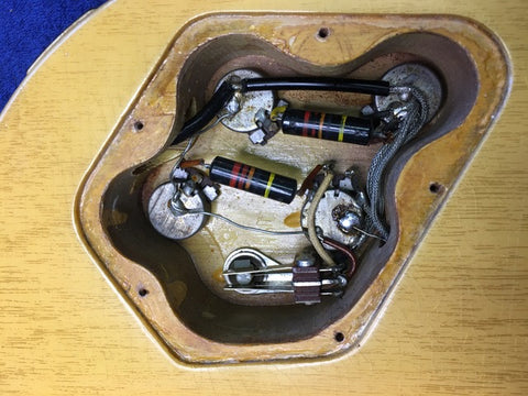 Electric guitar: 1958 Gibson Les Paul Special Double Cut, featuring visible wires and a pickup, exemplifying vintage craftsmanship.