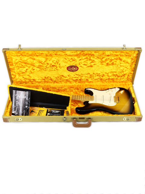 Electric guitar in a yellow-lined case with accessories.