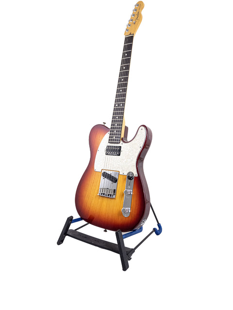 Fender American Standard Telecaster guitar on a stand, set against a clean white background, showcasing its sleek design.