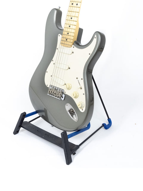 Fender Eric Clapton Signature Series Stratocaster guitar with a black body, elegantly positioned on a stand.