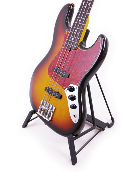 Fender Jazz Bass from Japan (1986/87) displayed on a stand against a clean white background.