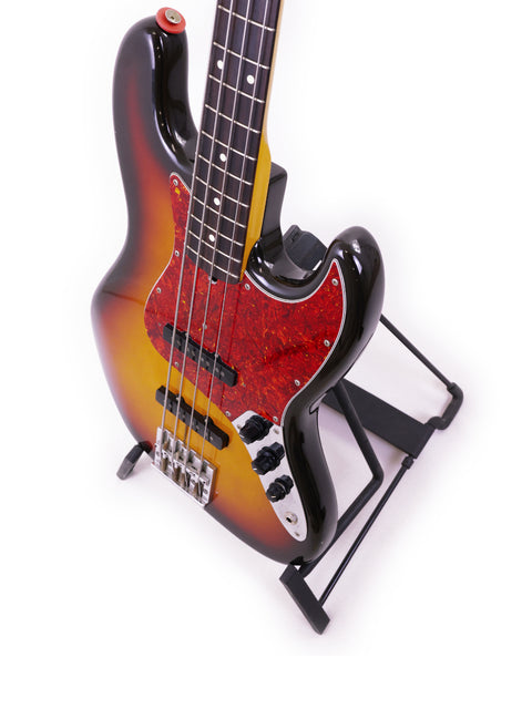 A Fender Jazz Bass, made in Japan (1986/87), showcased on a stand with a minimalist white background.