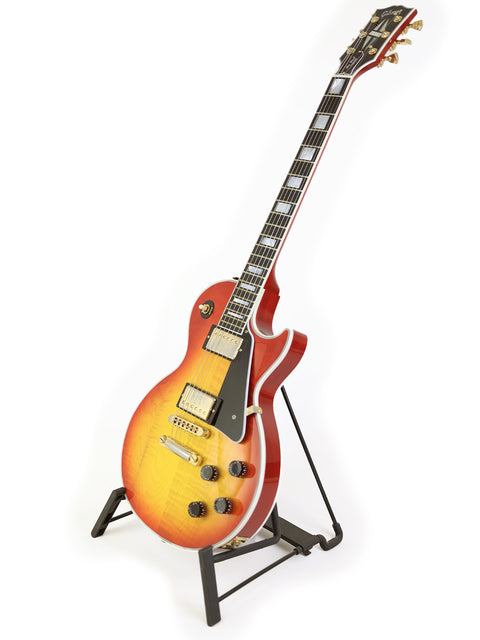 Gibson Custom Shop Les Paul Custom guitar displayed elegantly on a stand, showcasing its craftsmanship and design.