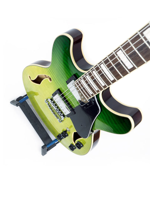 Green electric guitar, model Ibanez Artcore AS73 FM, with a stylish black pick guard, showcasing its semi-hollow body design.