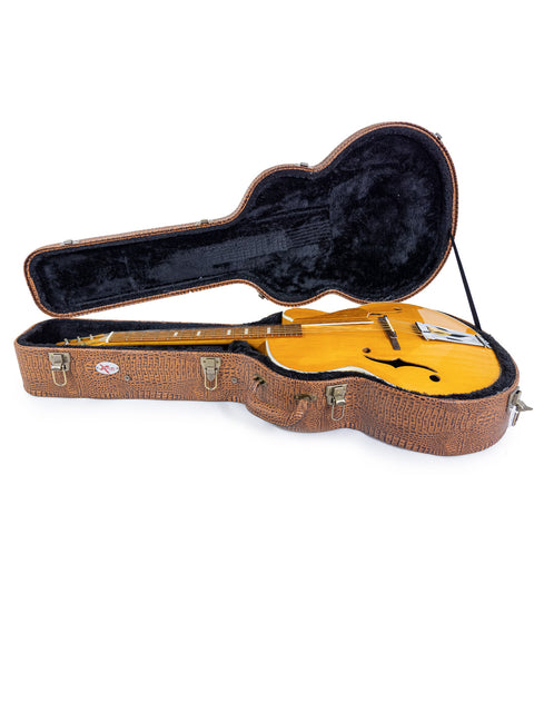 Inside a 1970s Sutton Archtop case, a vibrant yellow guitar is prominently displayed.