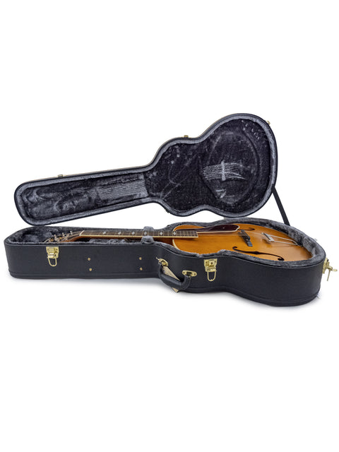Inside a black guitar case lies a 2016 Epiphone Masterbilt De Luxe F-Hole Archtop guitar, highlighting its classic craftsmanship.