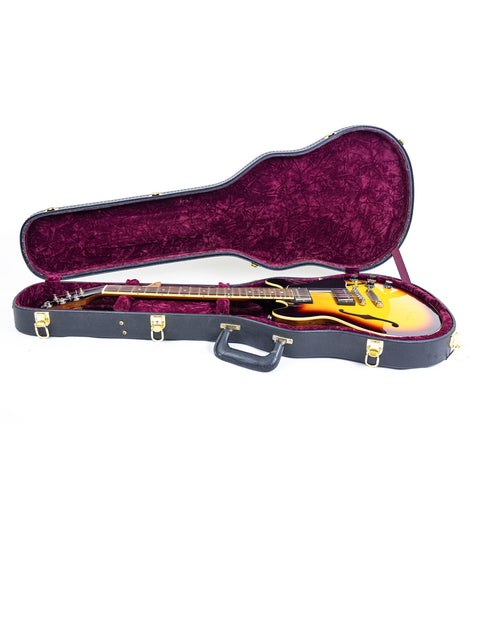 Inside a guitar case, a striking yellow Gibson Custom Shop ES 339 from 2009 gleams, highlighting its unique design and quality.